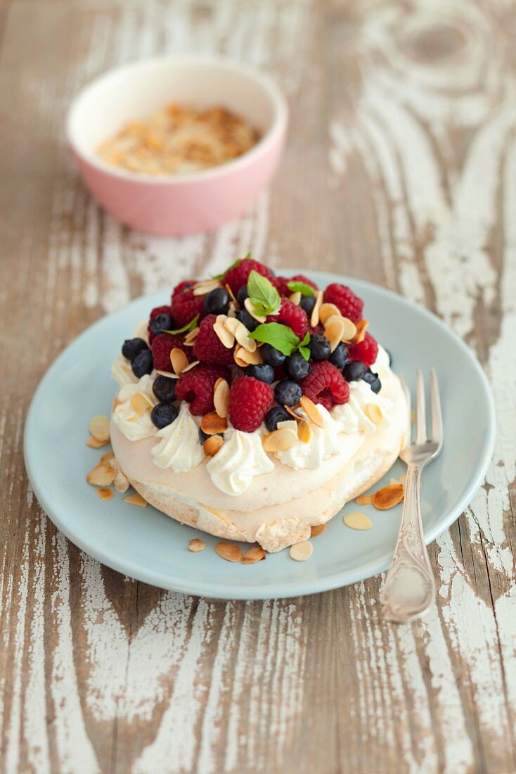 A mini Pavlova with berries and flaked almonds