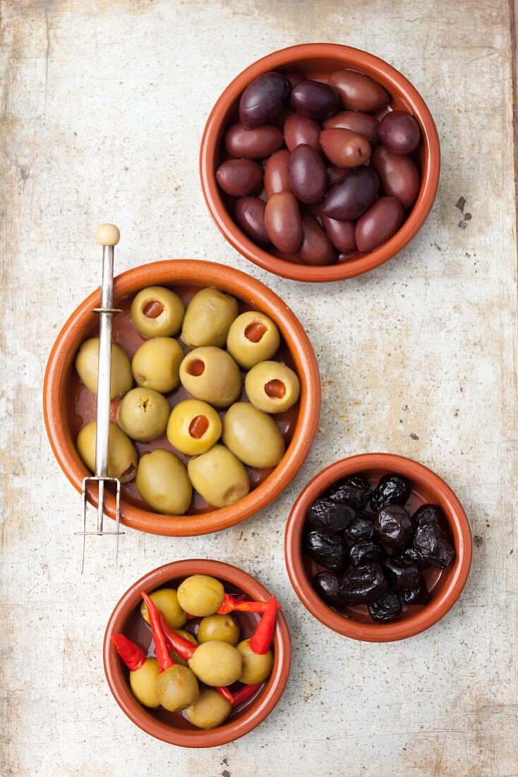 Verschiedene Oliven: getrocknet, Kalamata, mit Paprikafüllung und Piri Piri