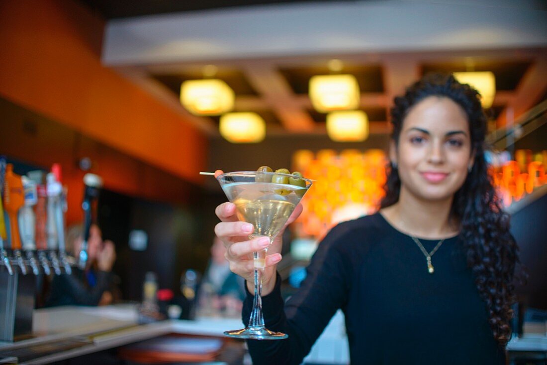 A young woman serving a cocktail