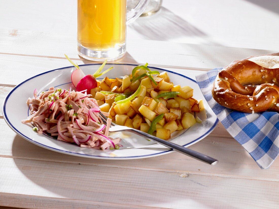 Fried potatoes with a sausage salad, petzels and beer (Bavaria, Germany)