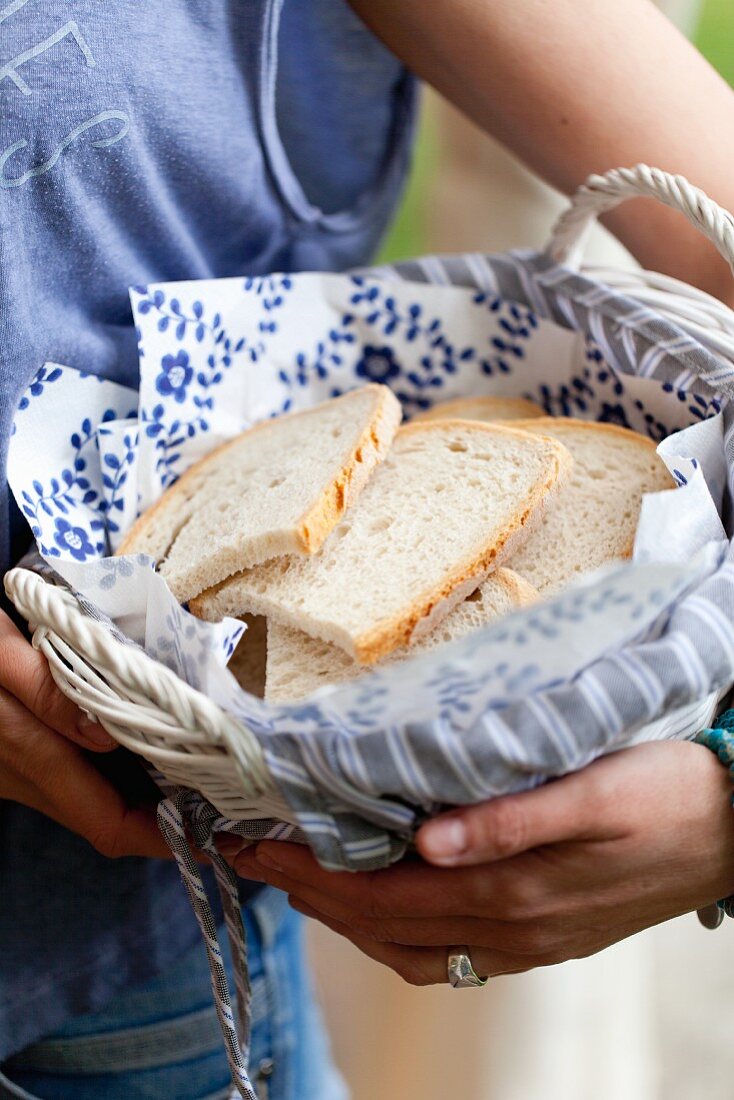 A woman holding a basket of bread