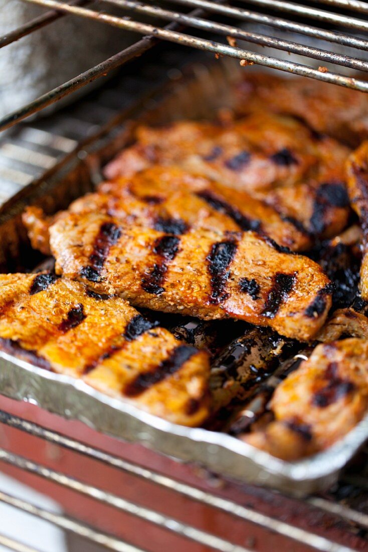 Grilled pork collar steaks in aluminium grilling trays