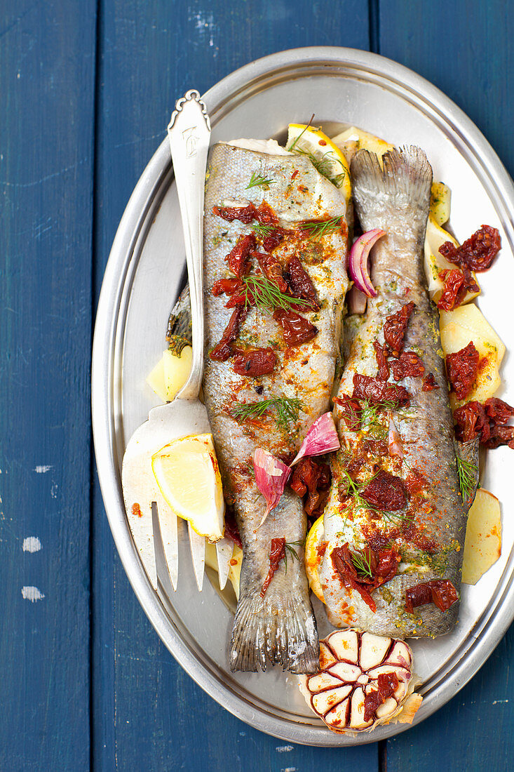 Gebackene Forellen mit Kartoffeln, Zitronen, Knoblauch und getrockneten Tomaten