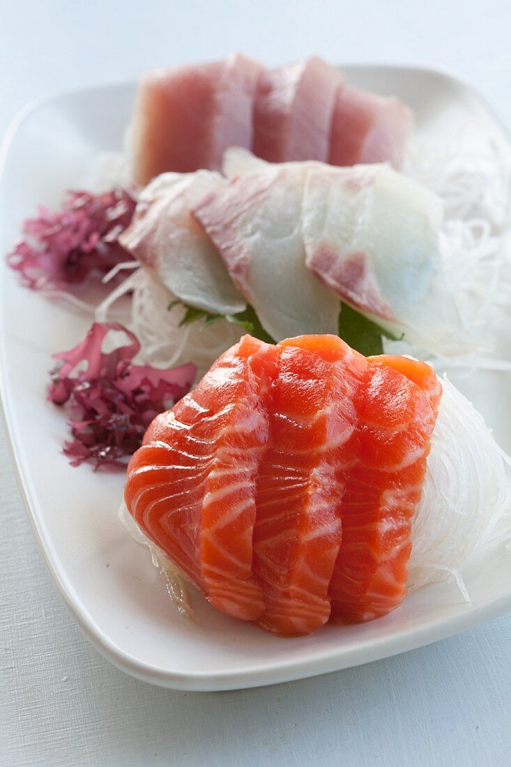 Sashimi on strips of radish with seaweed