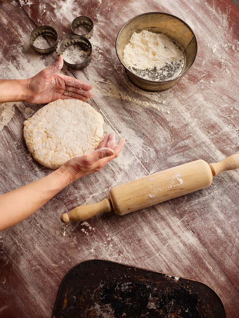 A person making scones: rolling out pastry