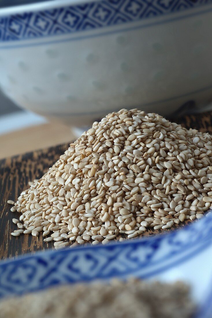 A pile of sesame seeds between oriental crockery