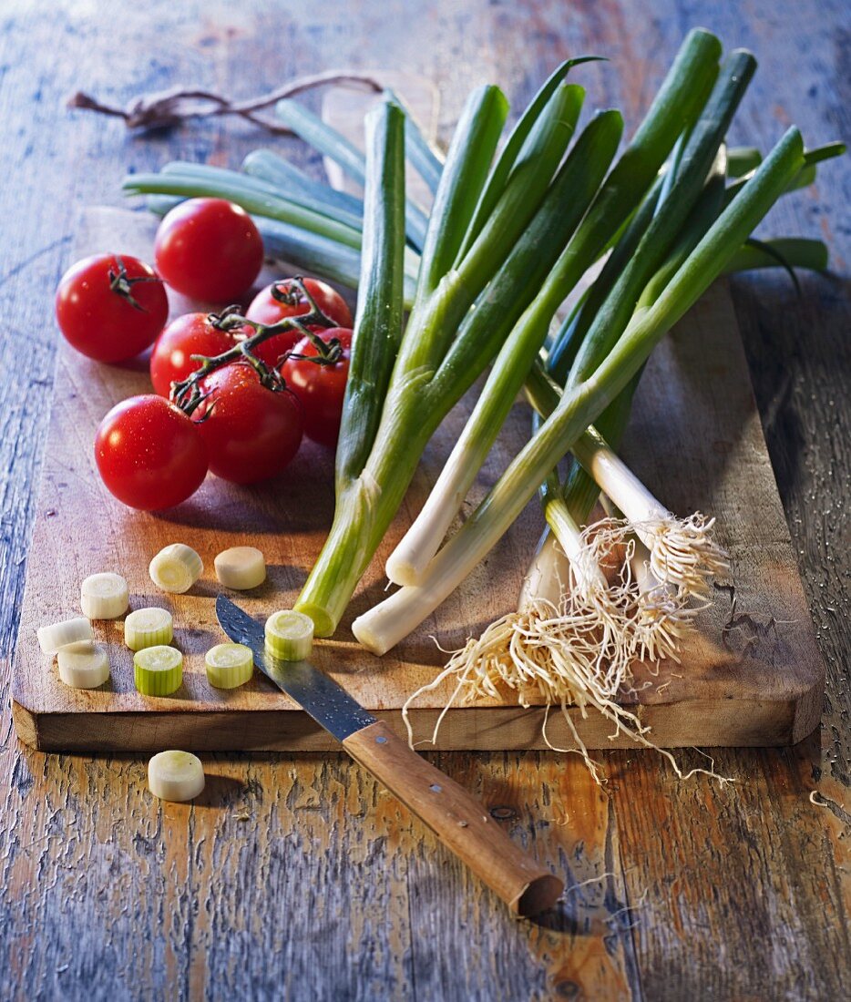 Gemüsestillleben mit Rispentomaten und Lauchzwiebeln