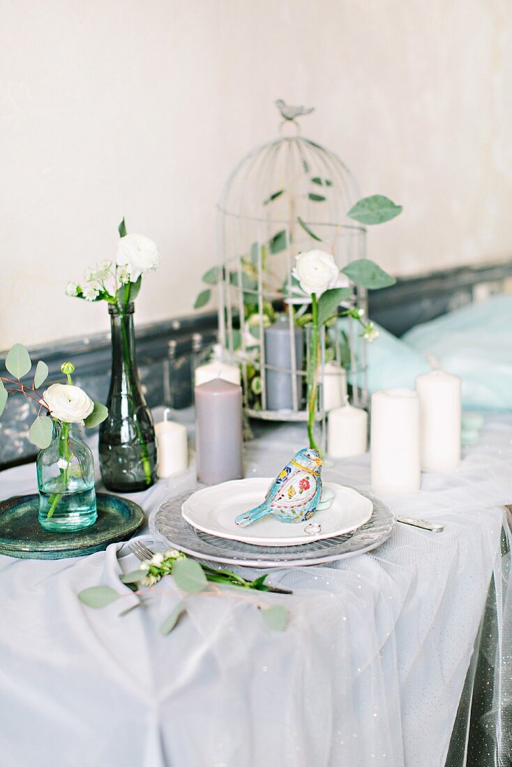 Fairy-tale dining table decorated for wedding with birdcage and many candles