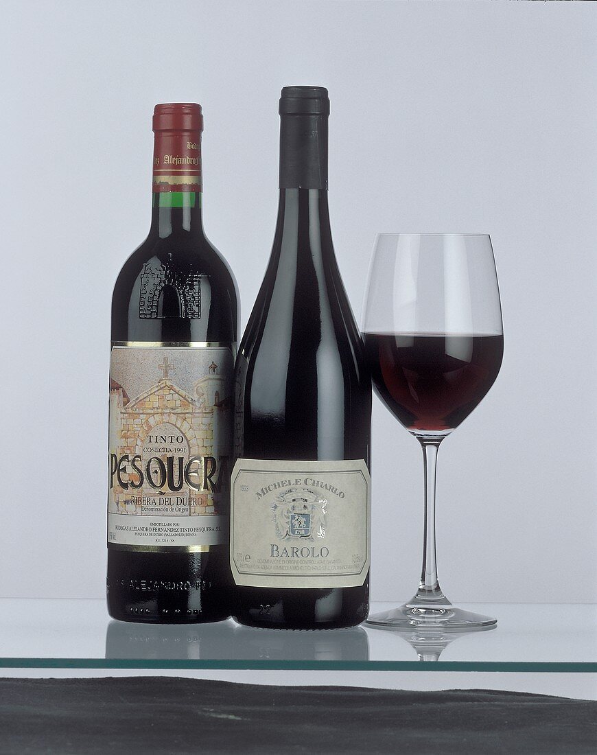 Bottle of Ribeira del Duero & of Barolo beside red wine glass