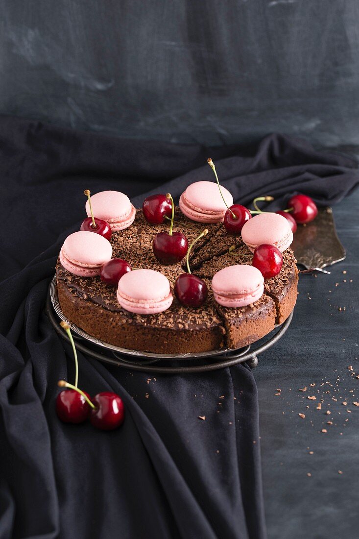 Chocolate and cherry cake decorated with pink macaroons