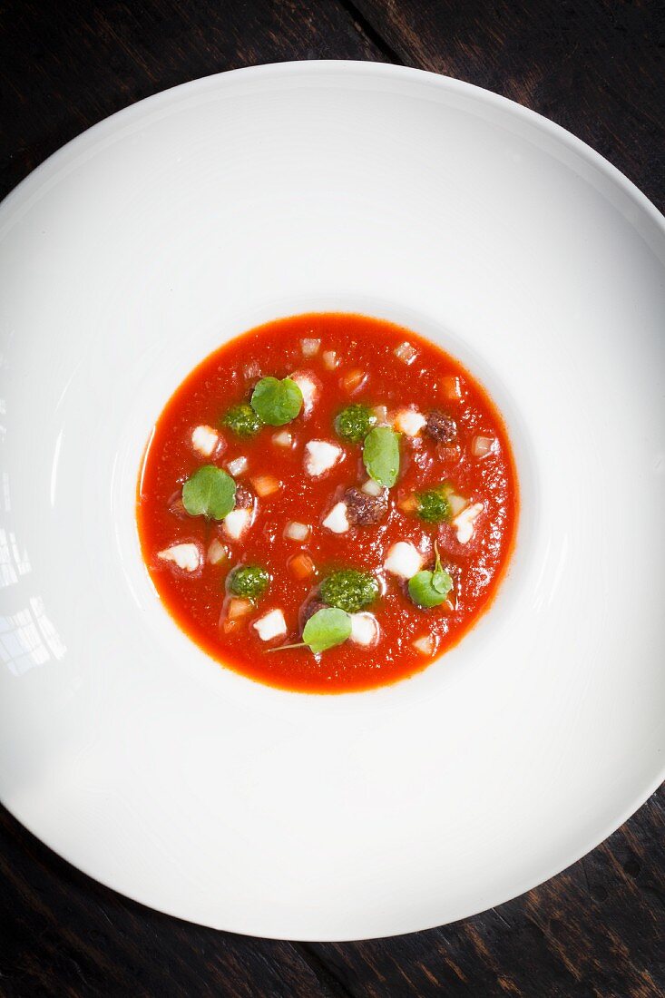 Cold tomato soup with mozzarella and pesto (seen from above)