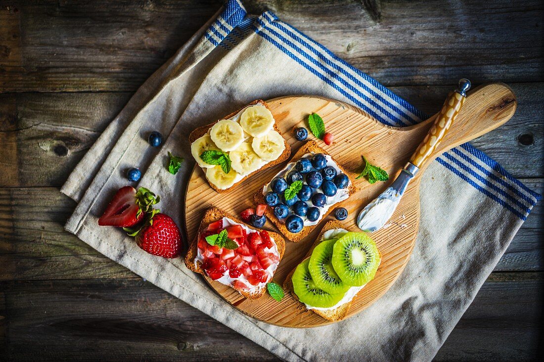 Healthy fruit open sandwiches on a wooden board