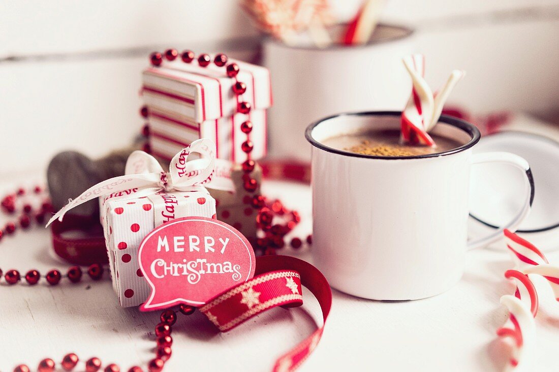 Heiße Schokolade mit Zuckerstangen und Weihnachtsdekoration