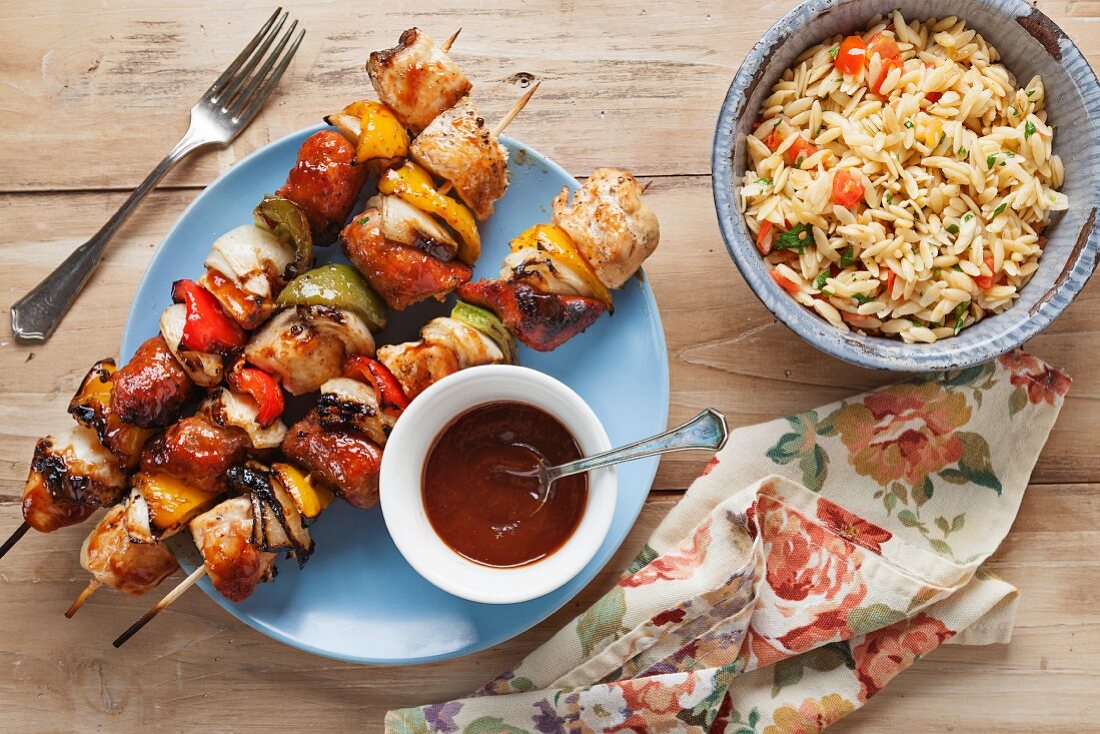 Chicken skewers with peppers and onions, and a bowl of orzo