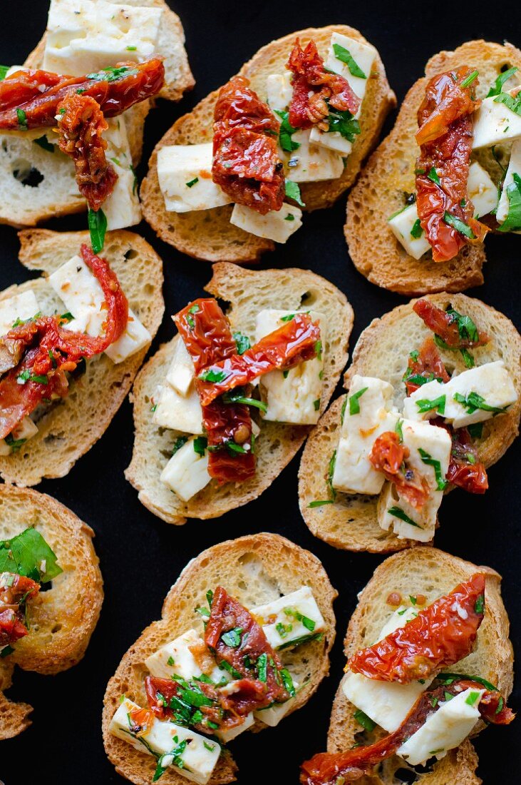 Bruschetta mit Feta, getrockneten Tomaten und Kräutern (Draufsicht)