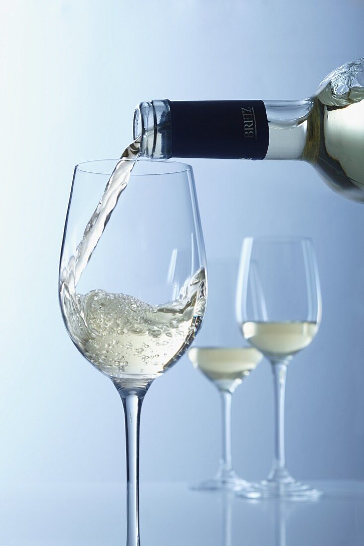 White wine being poured into glasses