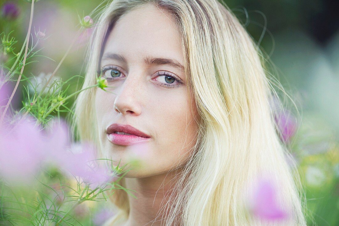 A portrait of a young woman in a field of flowers