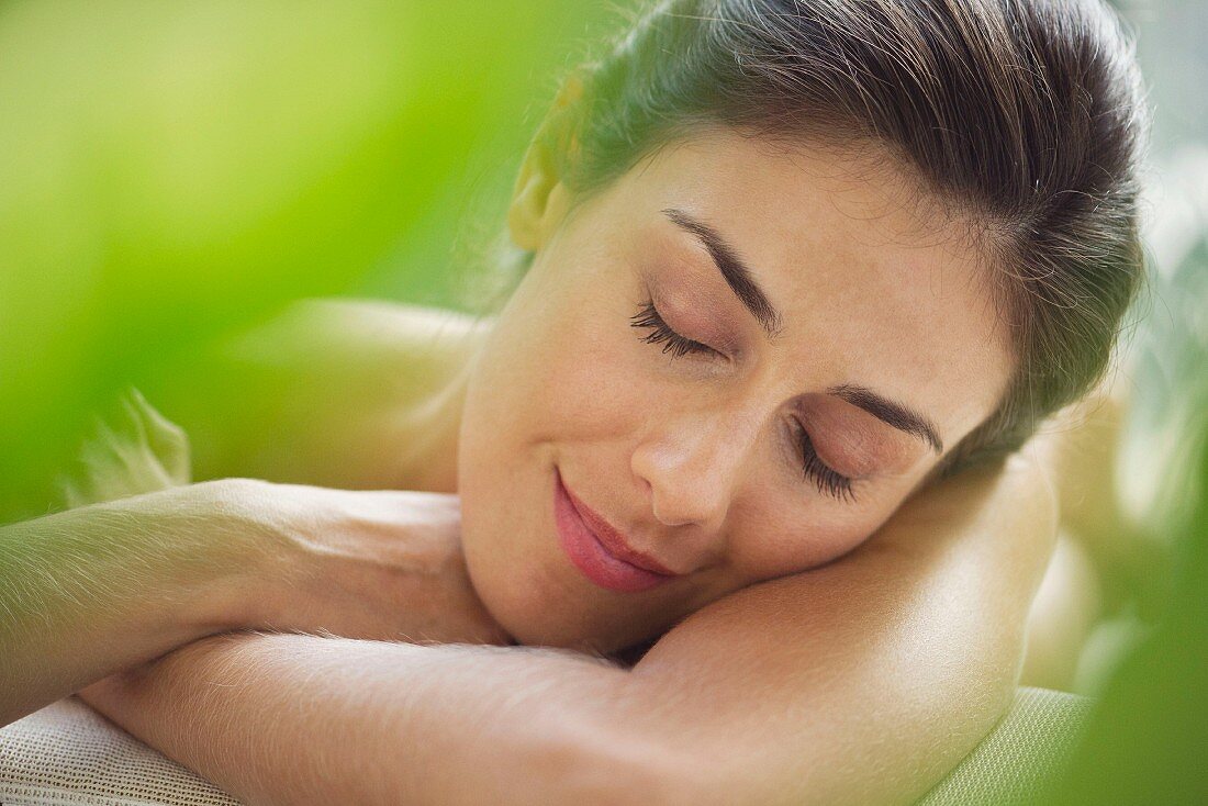Portrait von brünetter Frau mit geschlossenen Augen beim Relaxen
