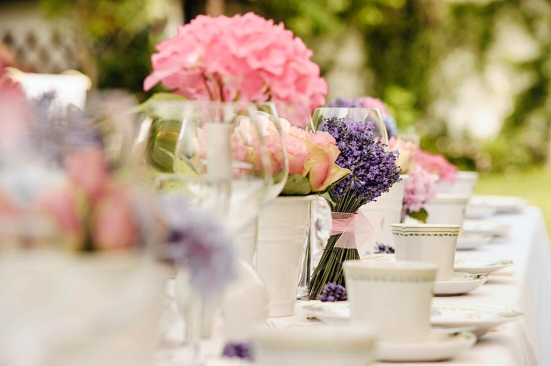 Long table set for afternoon coffee with posies of lavender and other flowers