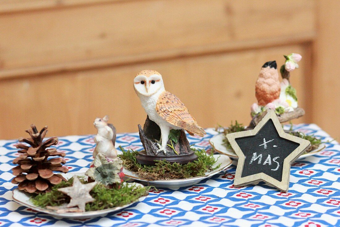 Festive table decorations with pine cones, moss, stars and animal ornaments