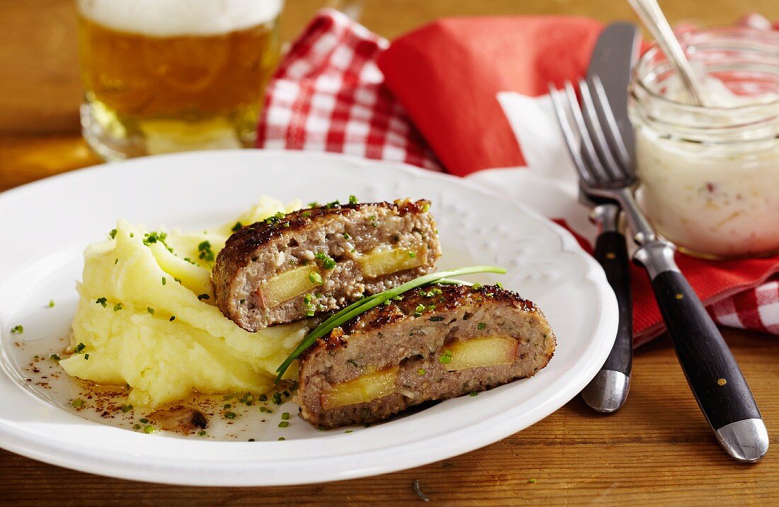 Minced meat steaks made with Appenzeller cheese and filled with apple served with mashed potatoes