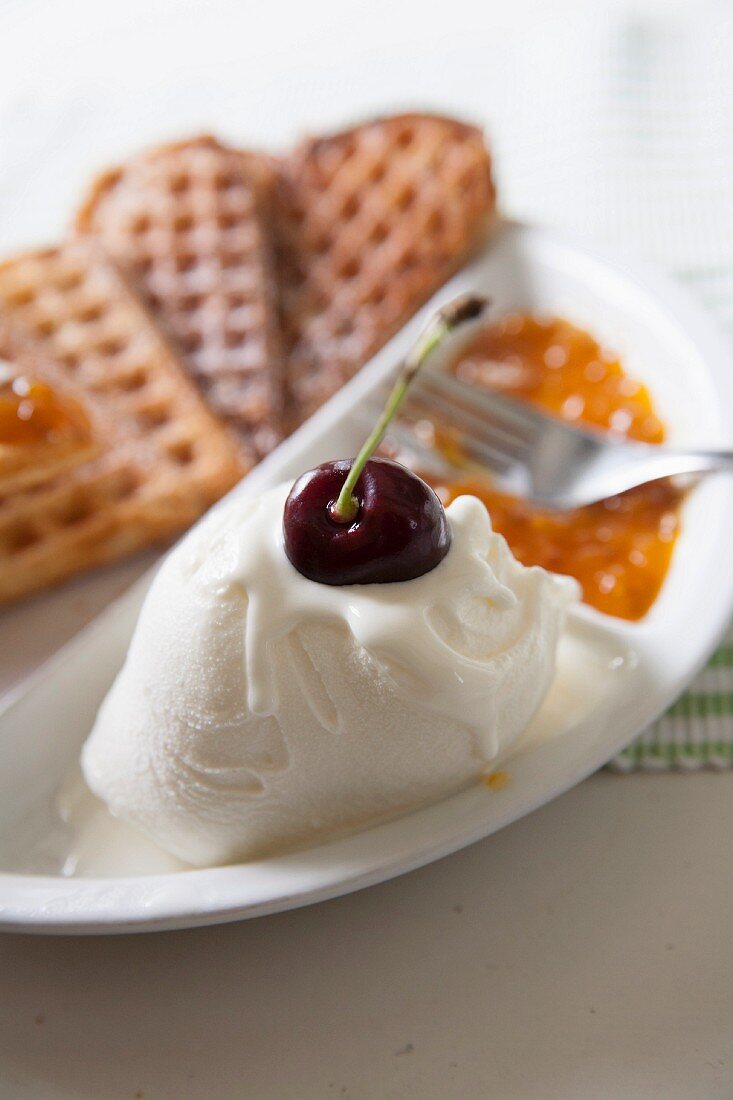 Heart-shaped waffles with vanilla ice cream and cloudberry jam