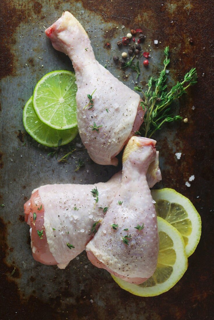 Raw chicken drumsticks on a metal surface