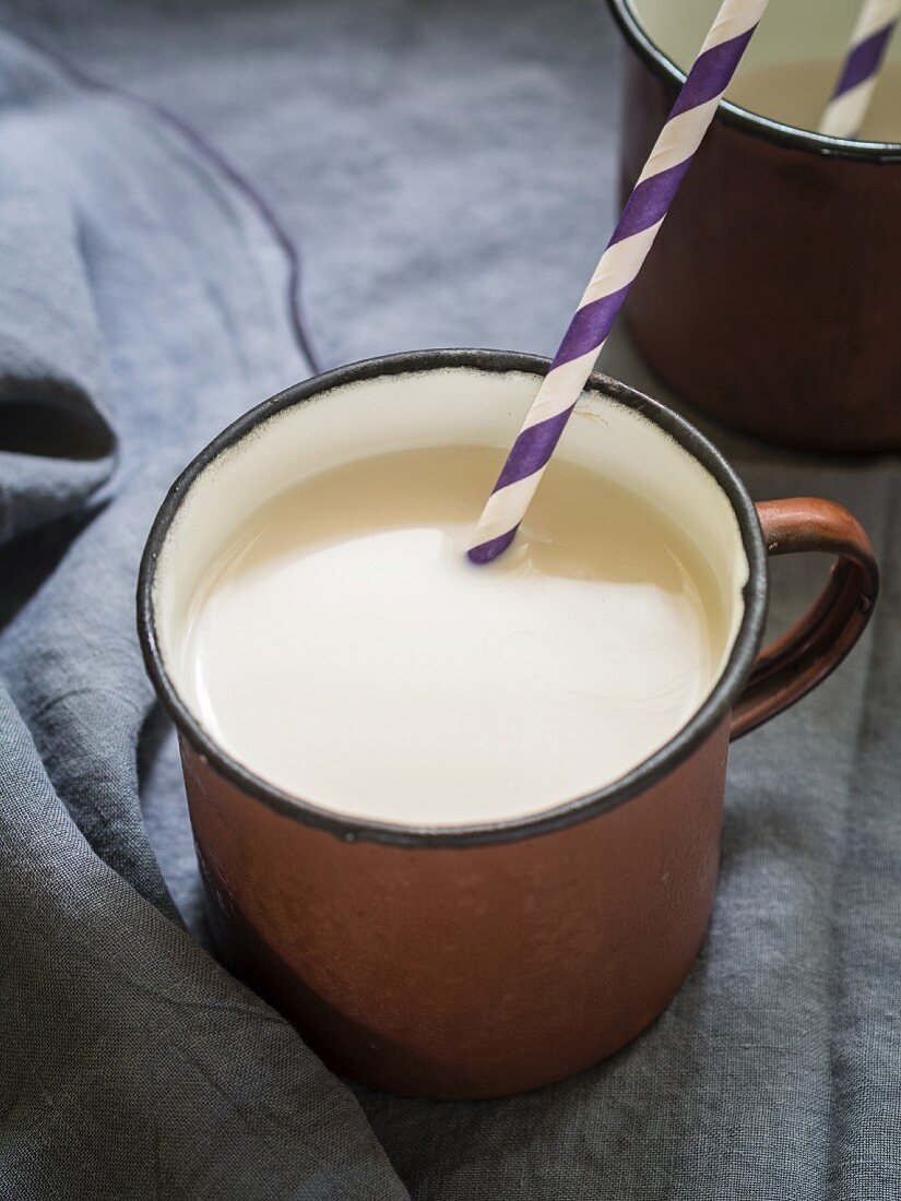 Organic almond milk in a rustic metal cup