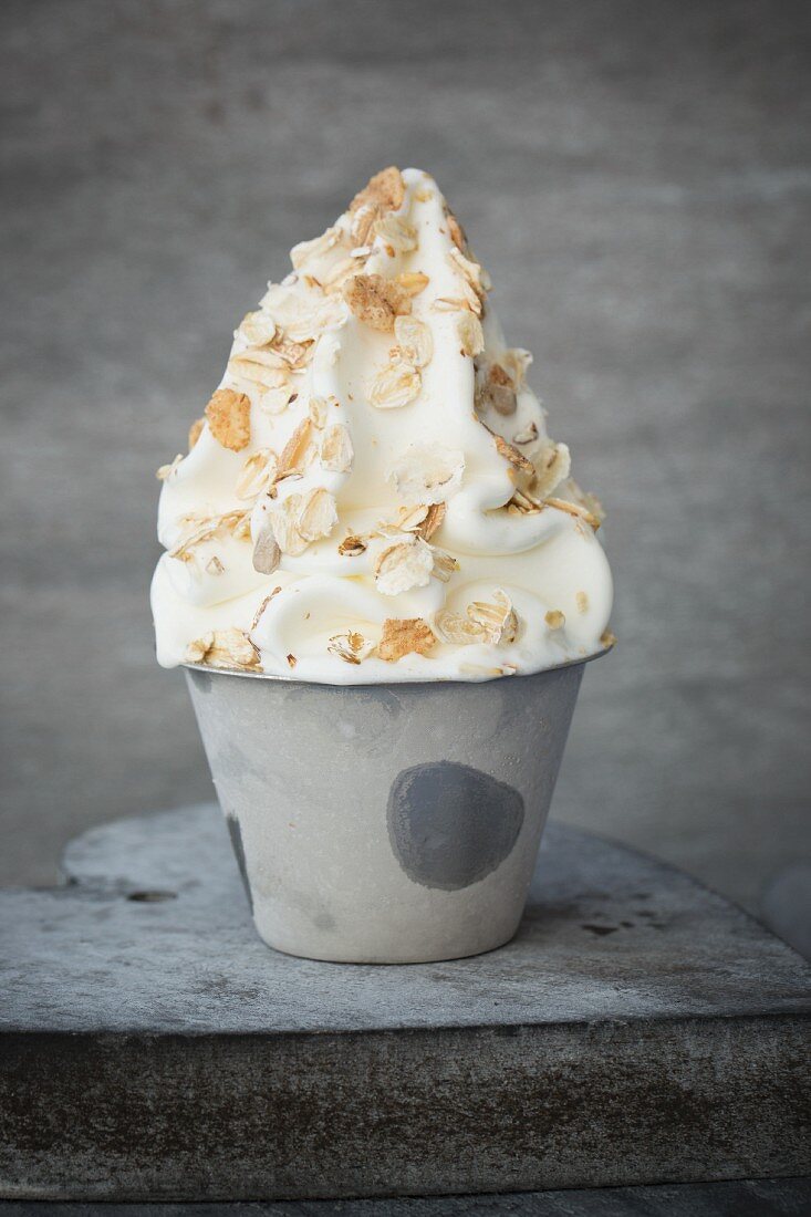 Frozen Yogurt in einem Metallbecher mit Müsli