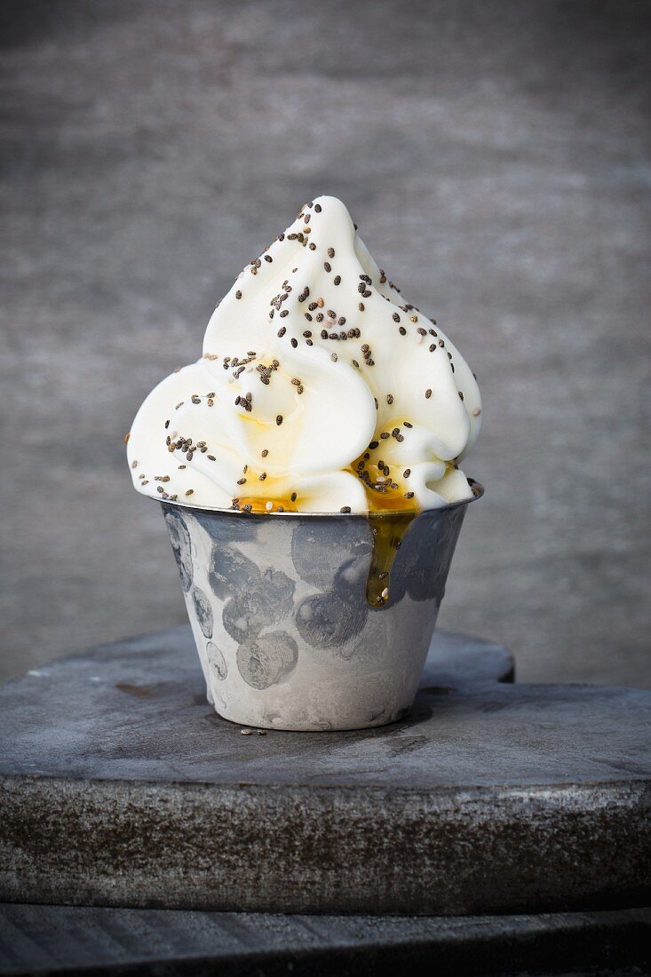 Frozen yoghurt in a metal cup with chia seeds and honey