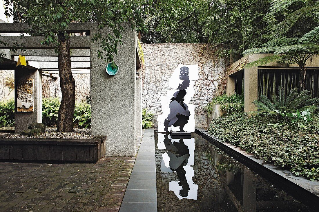 Rectangular pond and artworks in architectural garden