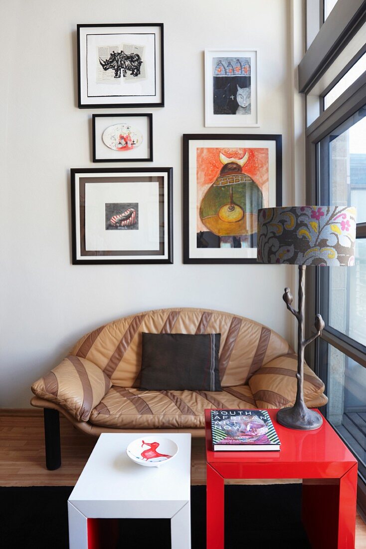Cubic coffee tables in front of striped leather sofa below gallery of pictures on wall
