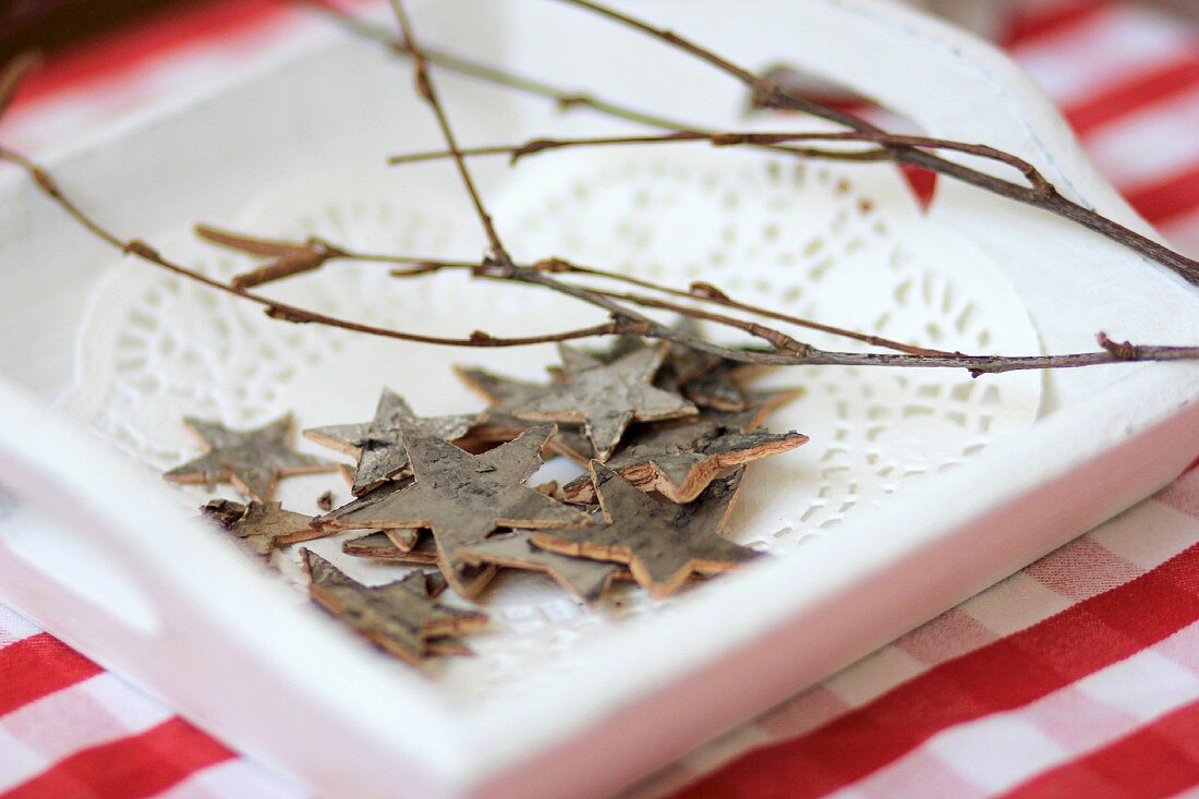 Star decorations made from bark on wooden tray
