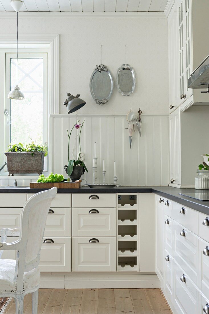 White country-house kitchen with panelled fronts and white wainscoting