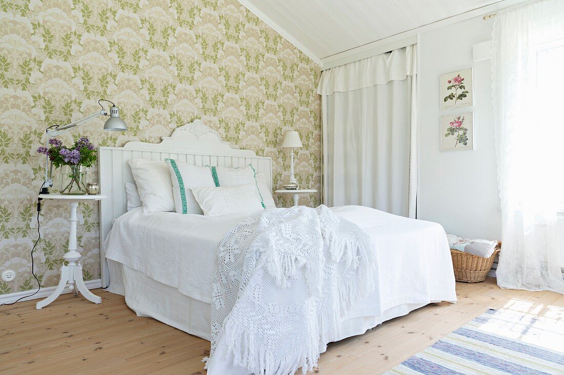 Green wallpaper and white furniture in Scandinavian-style bedroom