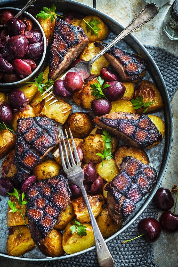 Duck breast with five spice powder on potatoes and cherries