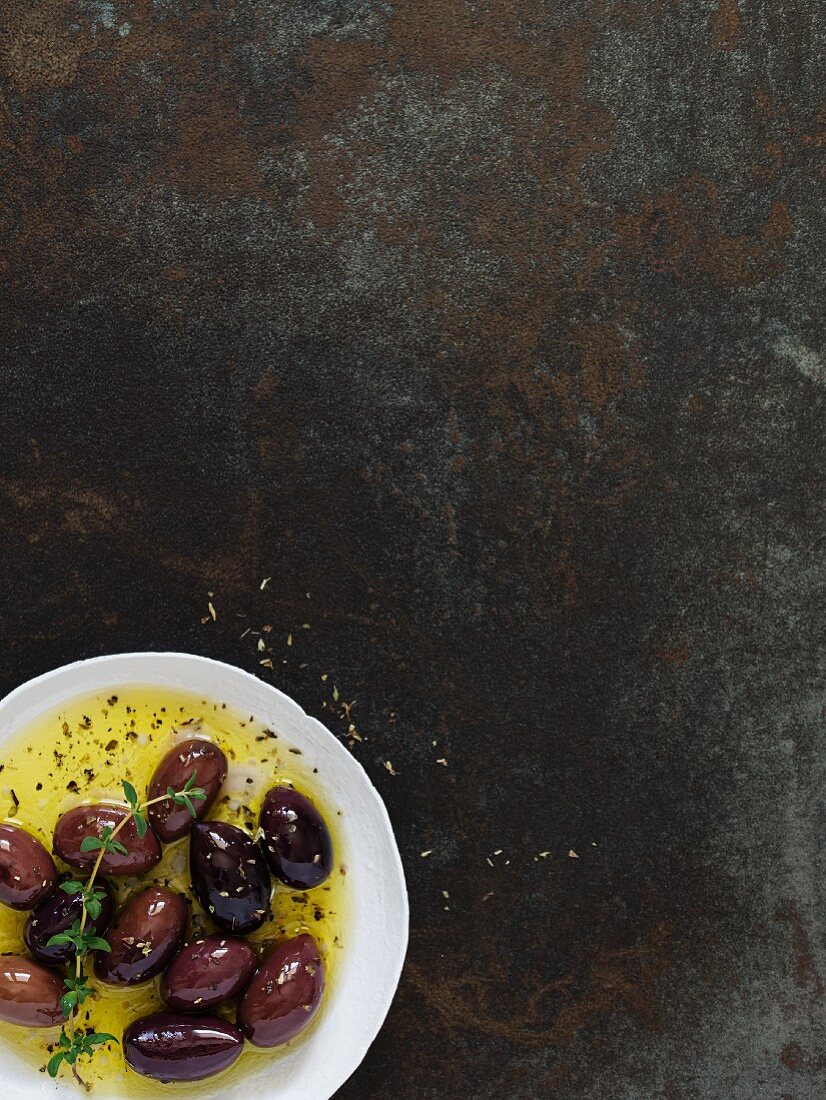 Marinierte Oliven auf rustikalem Hintergrund (Draufsicht)