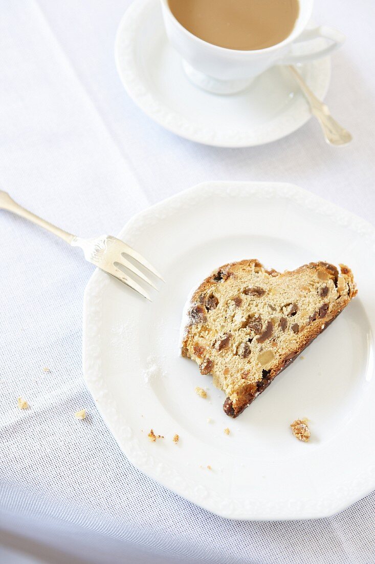 A slice of stollen with a cup of coffee