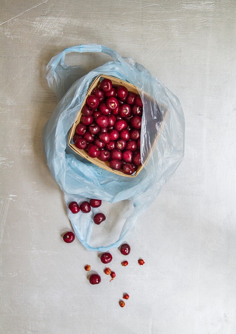 Sour cherries in a wooden basket in a plastic bag