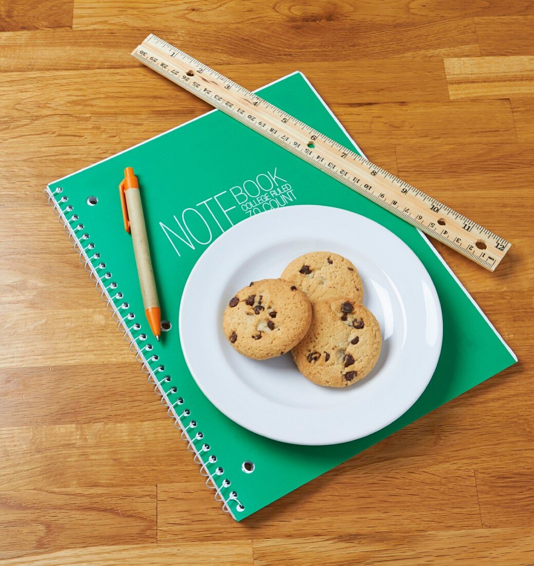 Chocolate Chip Cookies auf Notizblock daneben Lineal & Stift