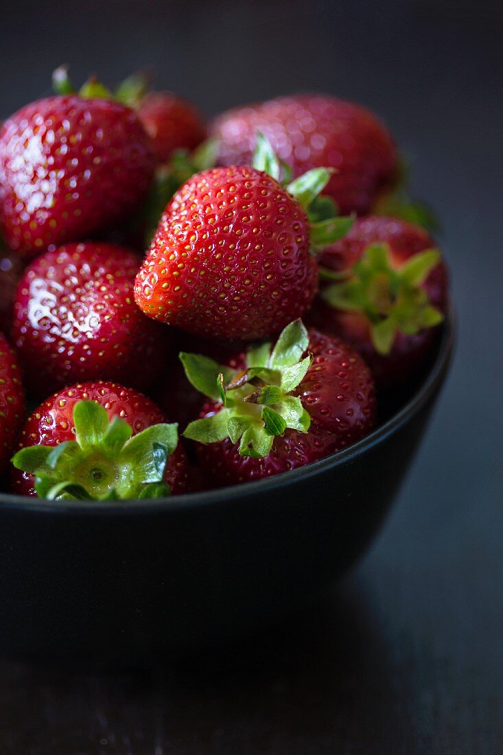Fresh strawberries in a black bowl
