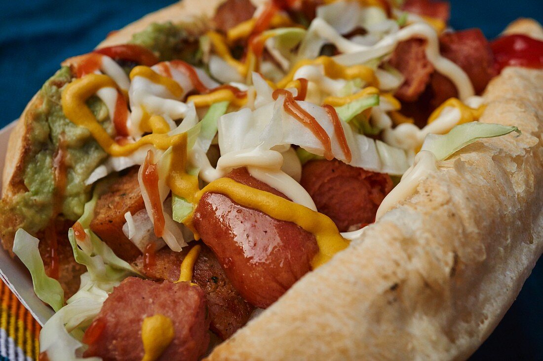 A hot dog with cabbage and guacamole (Guatemala)