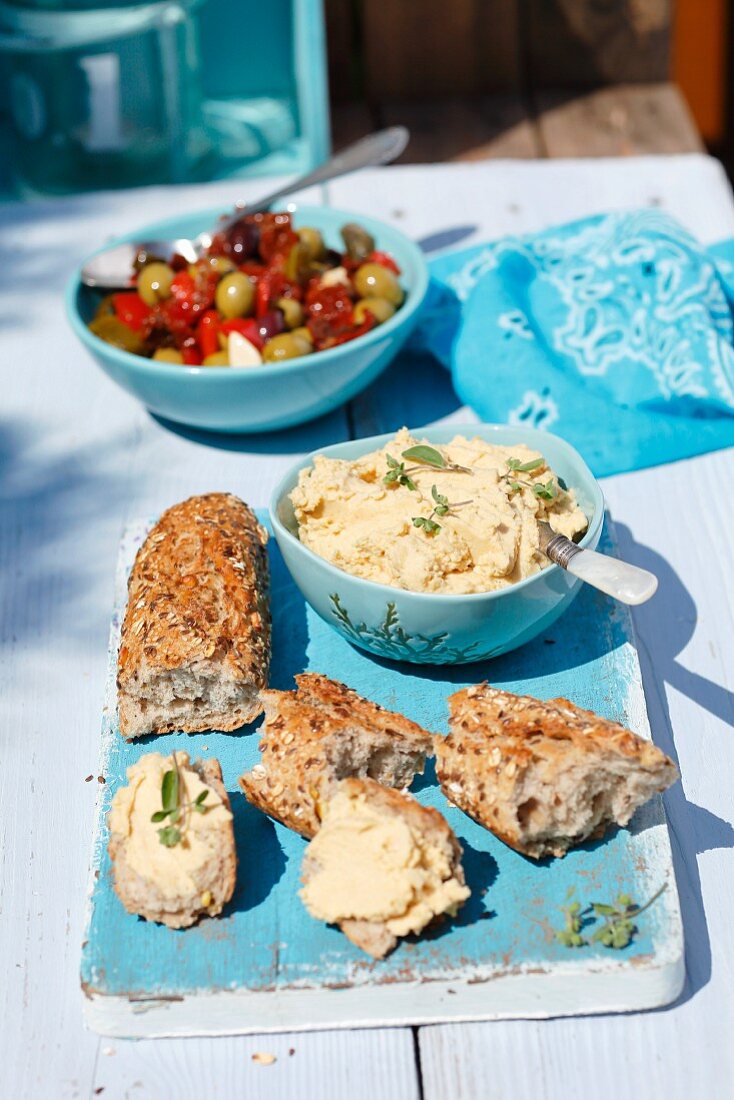 Vollkornbaguette mit Hummus und eingelegten Oliven