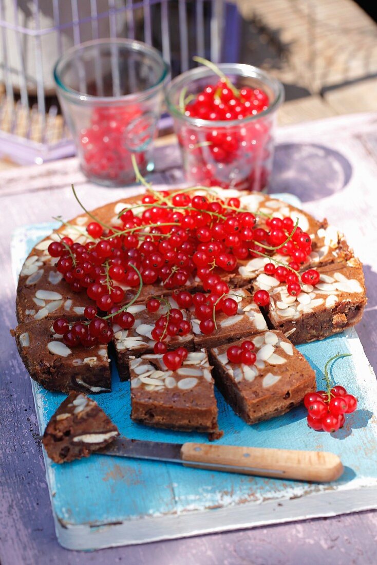 Schokoladenkuchen mit Mandeln und roten Johannisbeeren