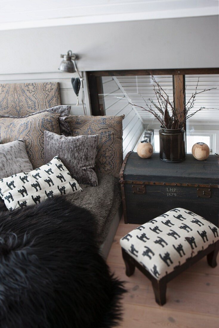 Upholstered footstool and trunk next to comfortable couch