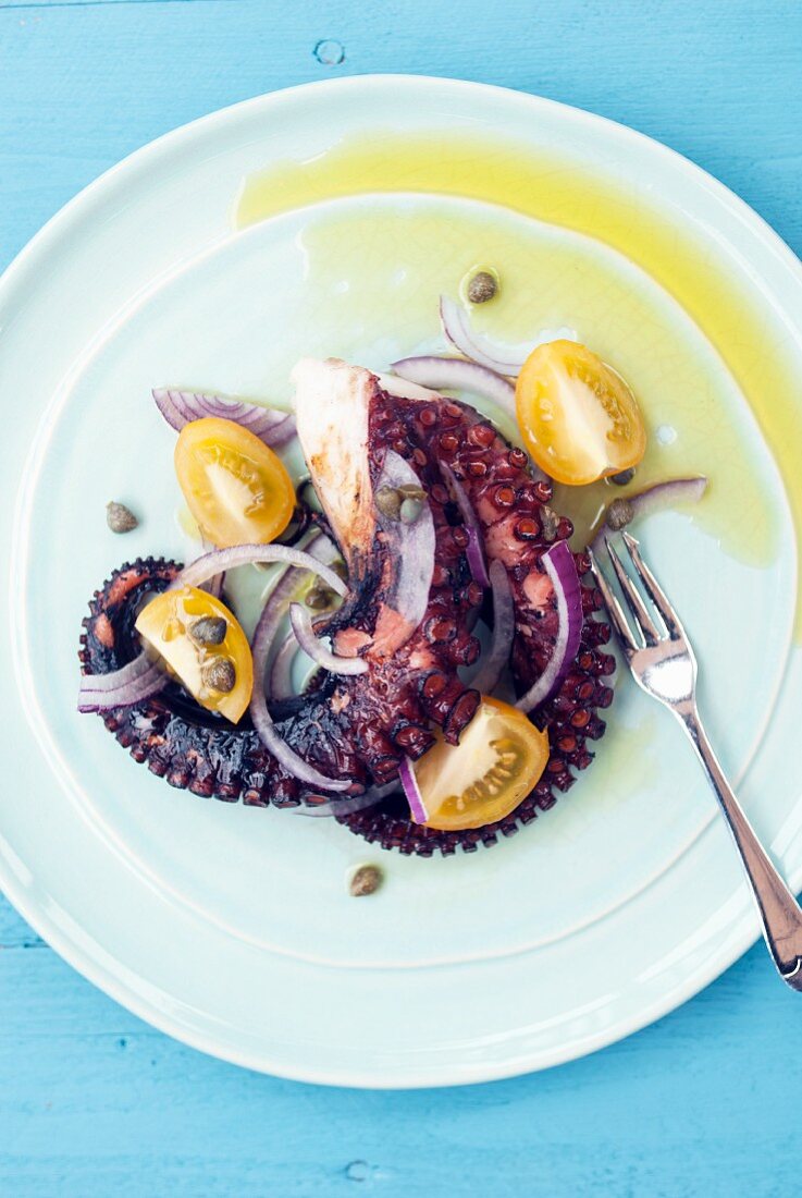 Gegrillter Oktopus mit roten Zwiebeln, Kapern und Tomaten