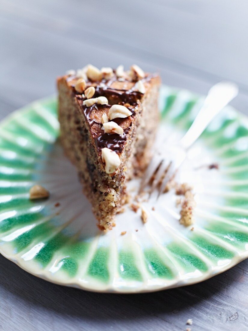 A slice of nut cake with chocolate drizzle