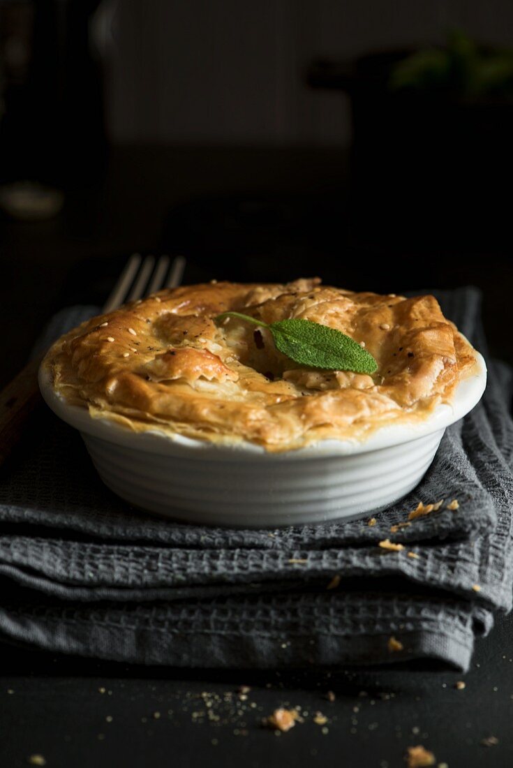 A chicken and mushroom pie in a white baking dish (close-up)