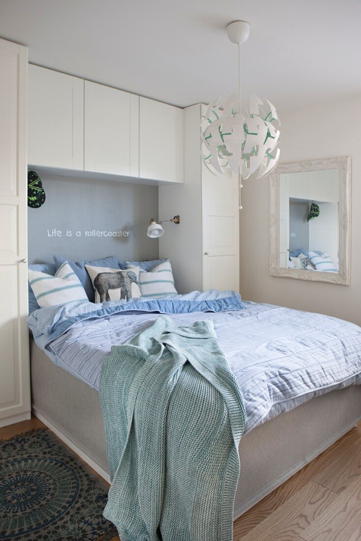 Wardrobes and wall-mounted cabinets framing bed headboard