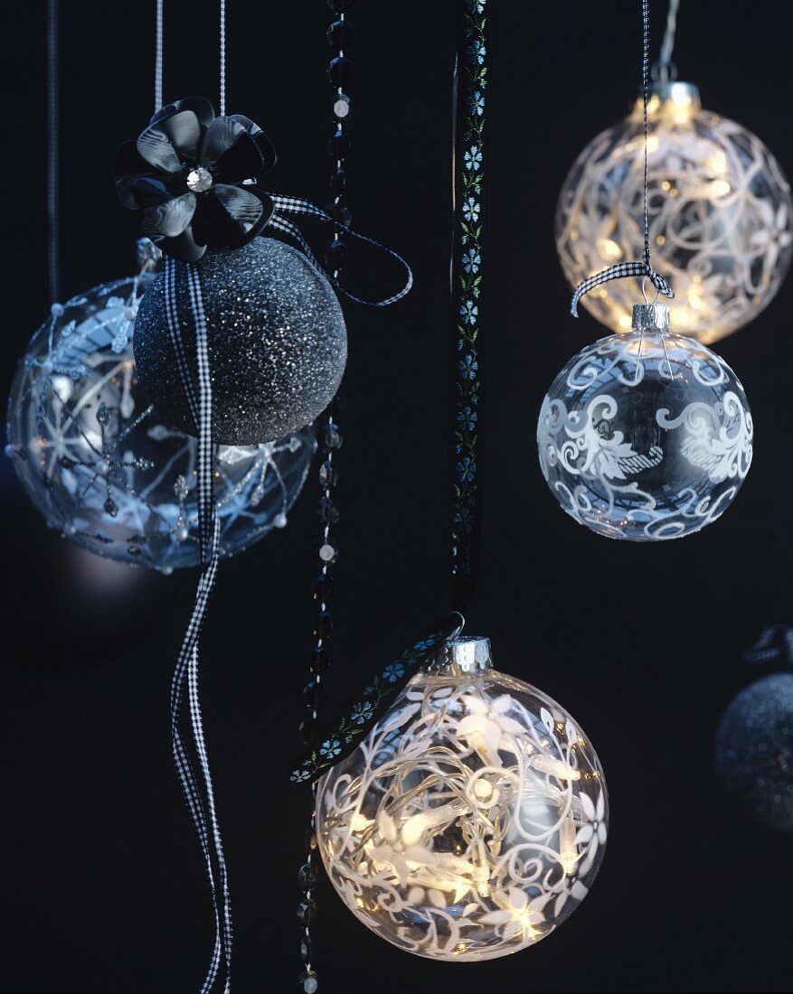 An Bändern aufgehängte Weihnachtskugeln in Schwarz & aus Glas